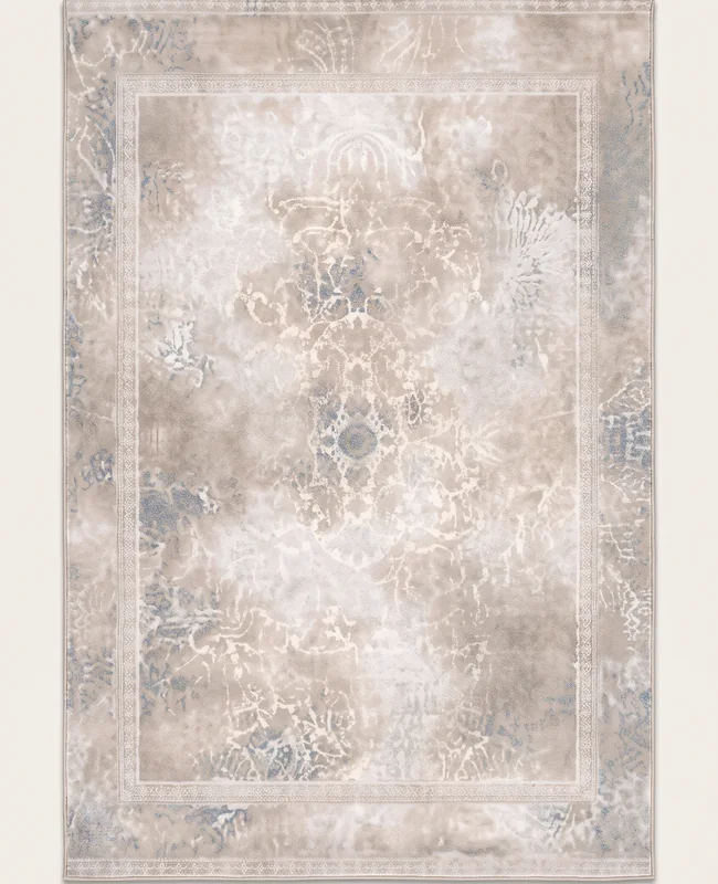 A pale distressed rug with a faded central design framed by a slim, low-contrast border.