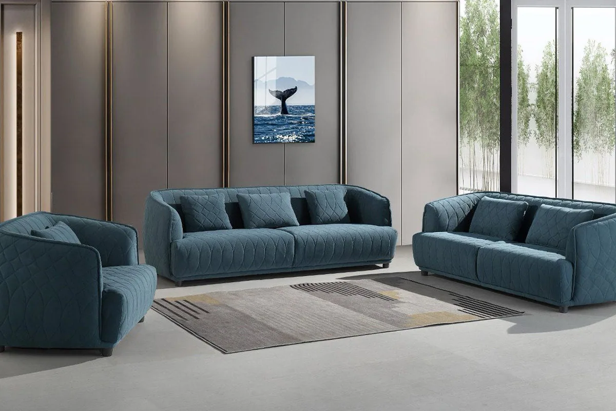 A teal quilted three-piece sofa set with clean lines in a minimalist living room.