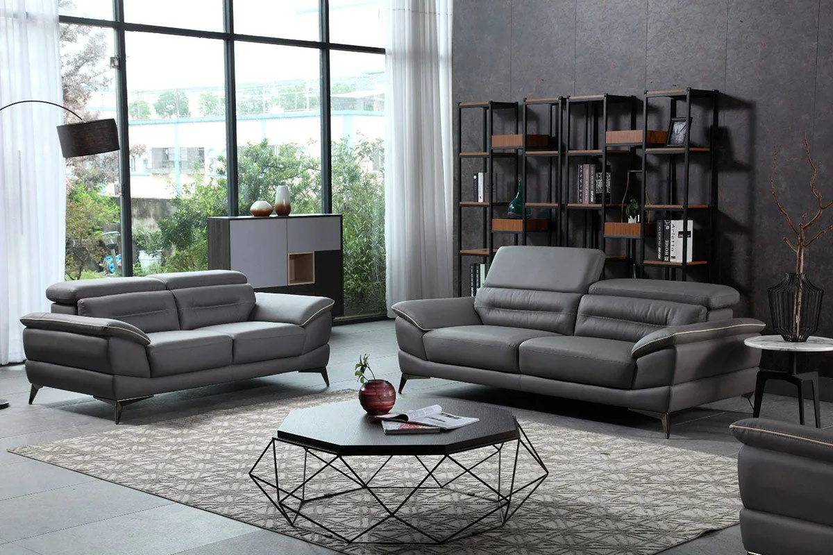A grey sofa set with adjustable headrests and slim metal legs in a modern lounge.