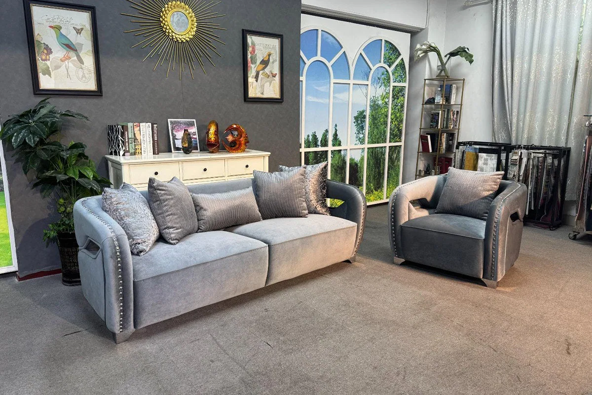 A large eight-seater sofa set in soft fabric with stud detailing along the arms.