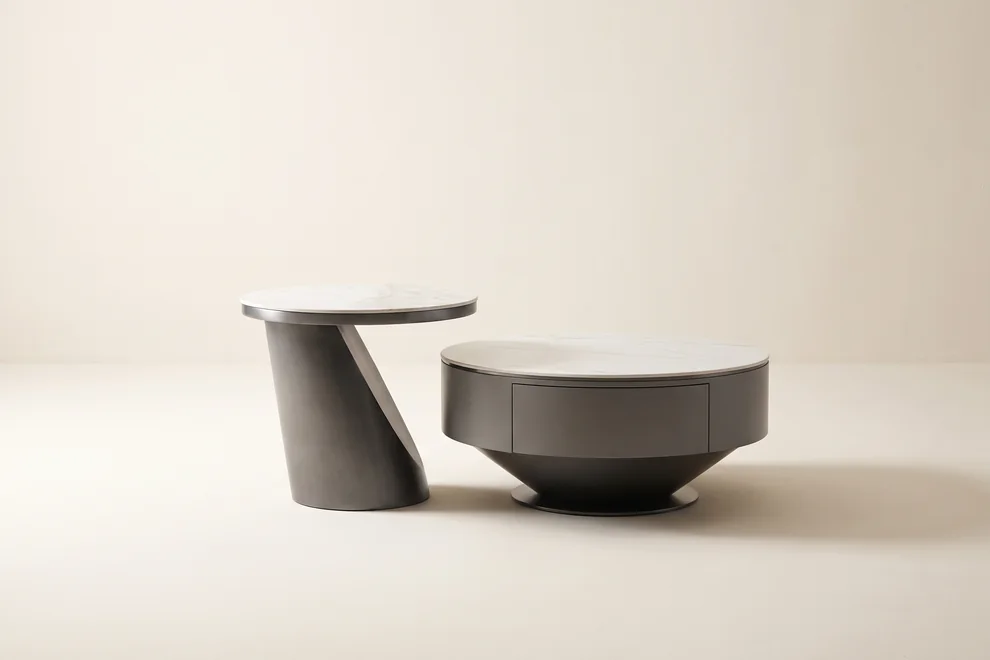 Set of marble-topped nesting coffee tables with curved bases, one tucked partly under the other.